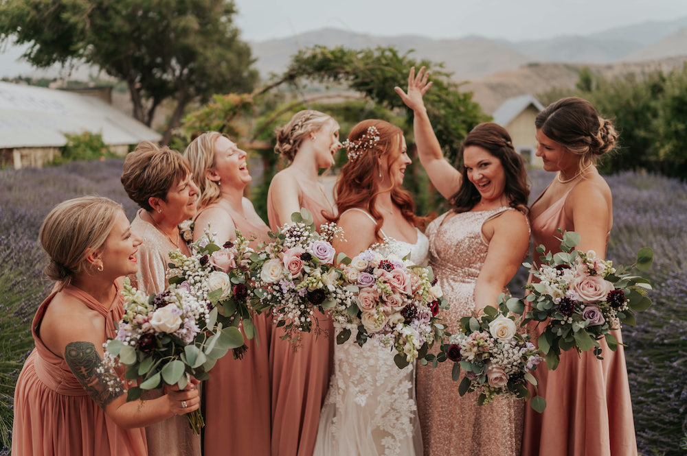 Bride and Bridesmaids smile towards each other during a wedding day
