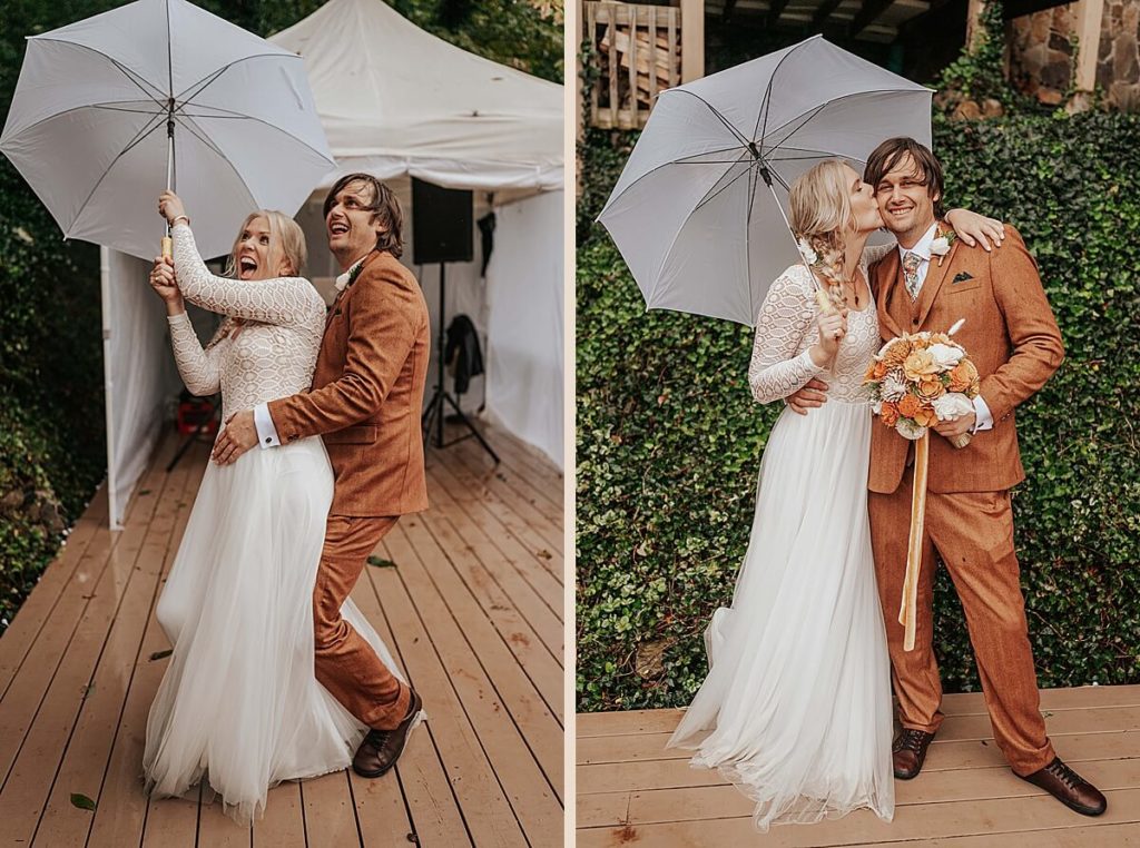 Boho bride and groom in a burnt orange suit holding an umbrella at their backyard wedding in Tennessee