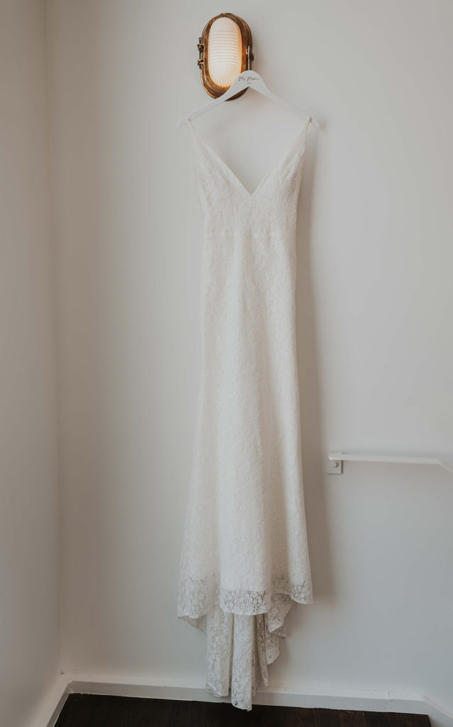 Hanging detail shot of an elegant white wedding dress.