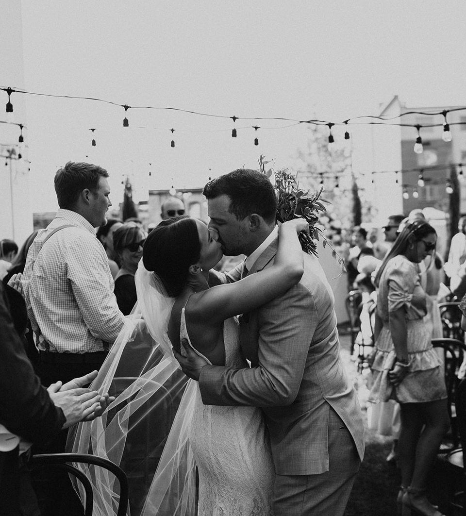Bride and groom wedding ceremony recessional kiss. 