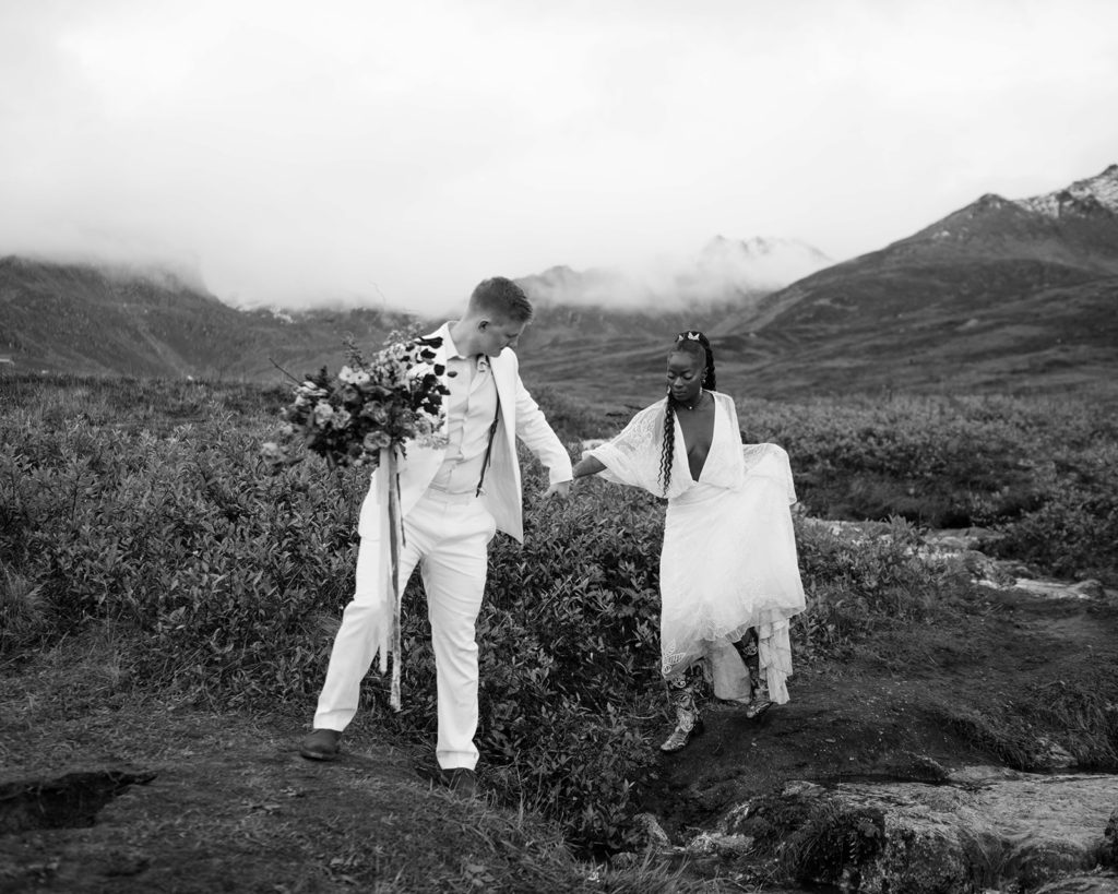 Bride and groom walking towards their outdoor wedding ceremony in Alaska.
