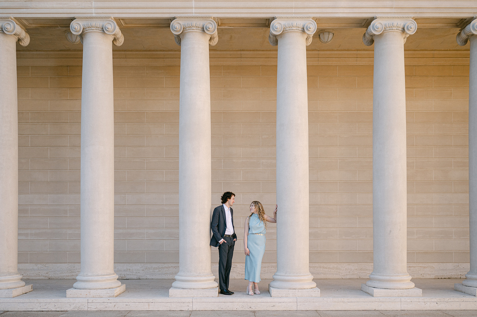 Couple stands among pillars at Legion of Honor, a San Francisco Engagement Photo Location.