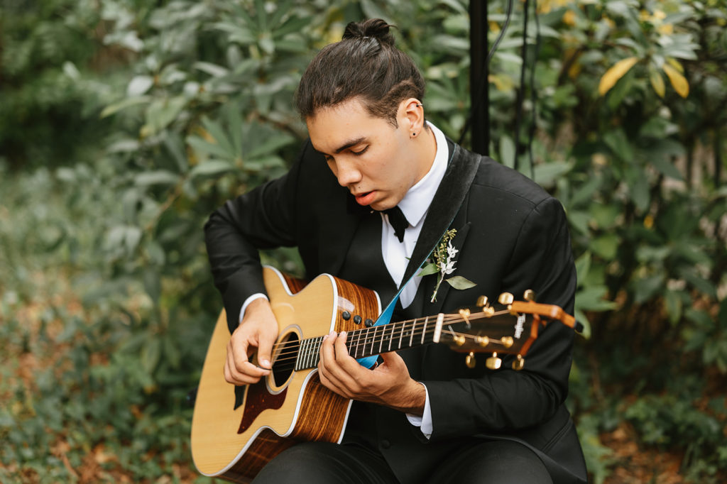 Bride's brother playing guitar before the ceremony