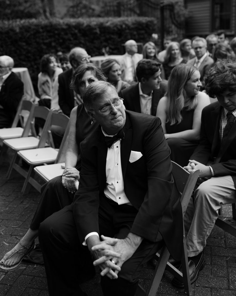 Father of the Groom holding back tears during wedding ceremony