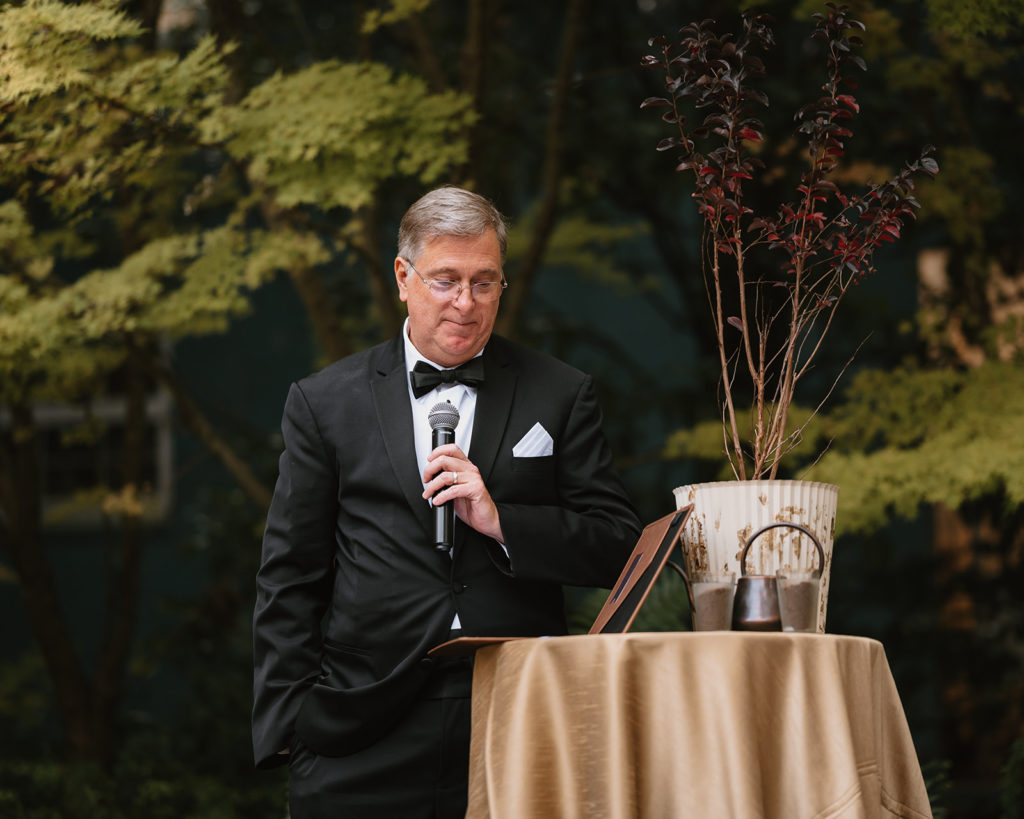 Father of the groom reads a poem during wedding ceremony