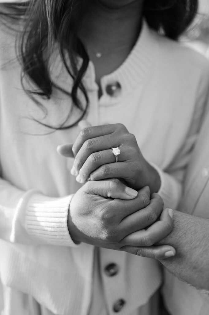 Couple hugs and shows off the woman's engagement ring after their  proposal.
