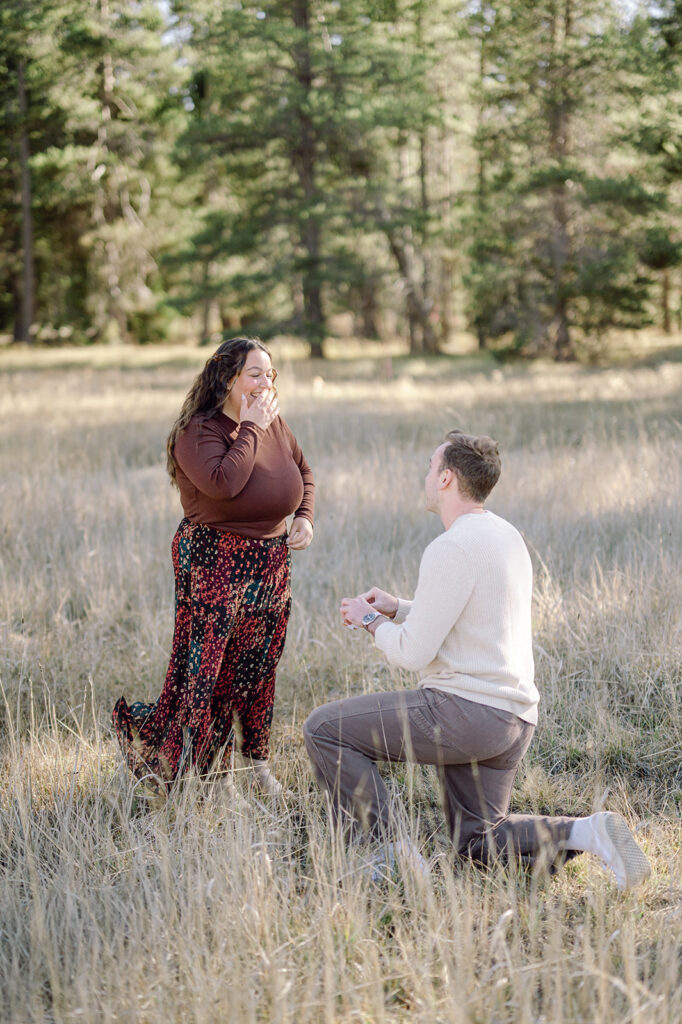 Man kneeling on one knee to propose during engagement photoshoot in Lake Tahoe.