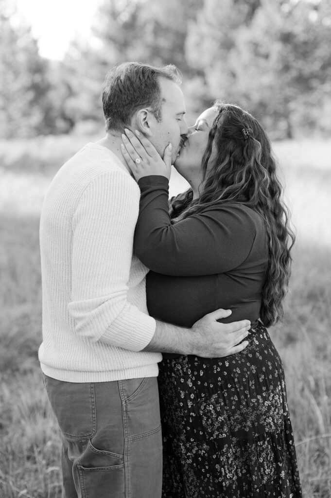 Couple embraces and kisses after becoming newly engaged in Tahoe meadow.