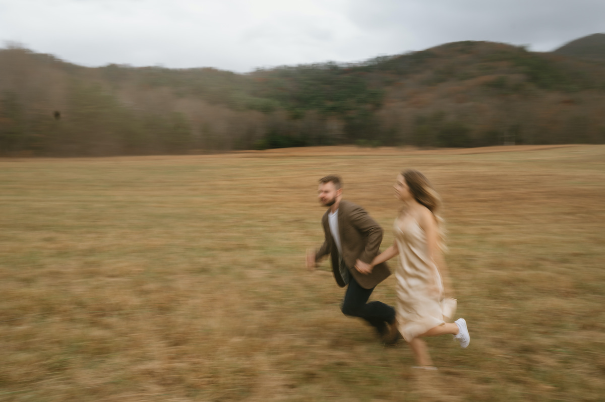 Blurry photo of couple running in an open field at Smoky Mountains National Park.