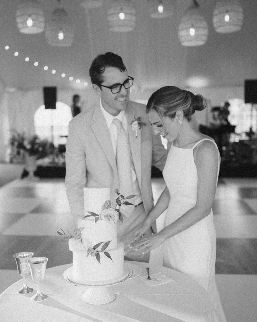 Cute candid moment of a bride and groom cutting their cake.