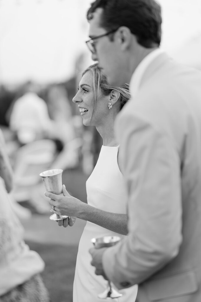 Candid moment of a bride and groom at cocktail hour.