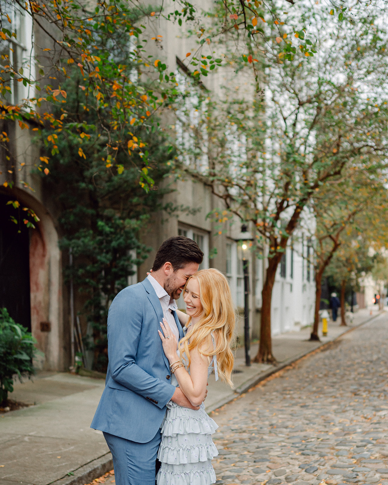 Husband and Wife embrace on the cobblestone streets of Charleston, SC.