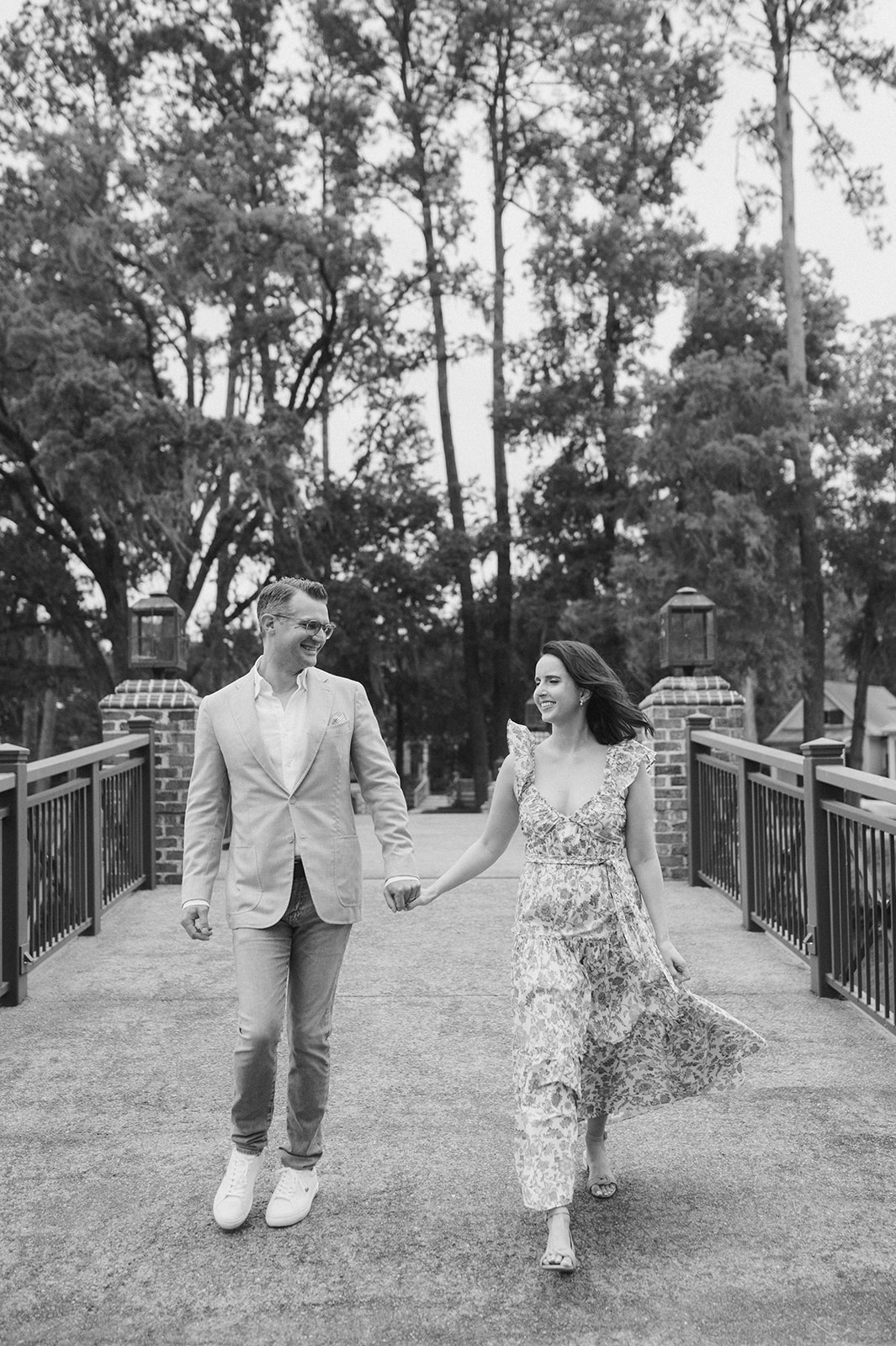 Couple holding hands and walking across the Palmetto Bluff Bridge near the Montage Hotel in Bluffton, SC. 