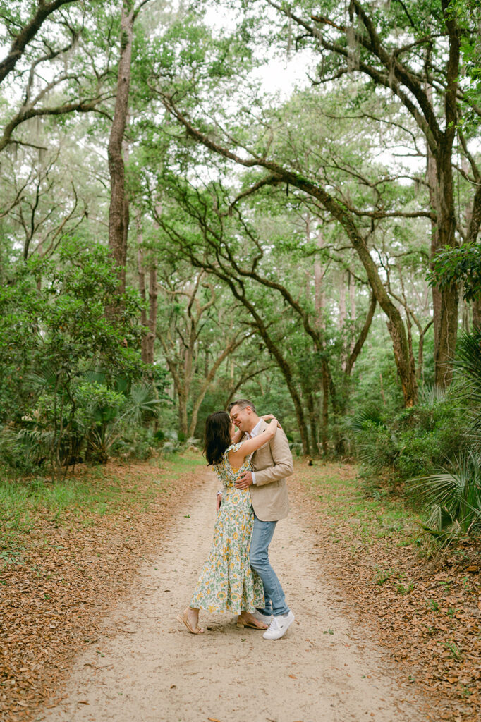 Couple kissing on a tree-lined path in Palmetto Bluff. 