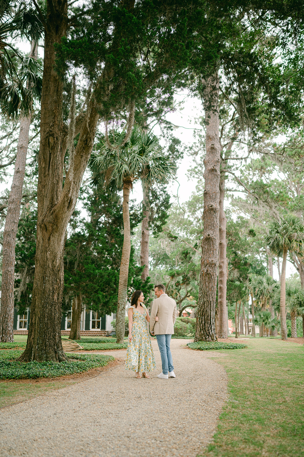 Couple posing on a gravel path under giant oak trees in South Carolina's Palmetto Bluff. 