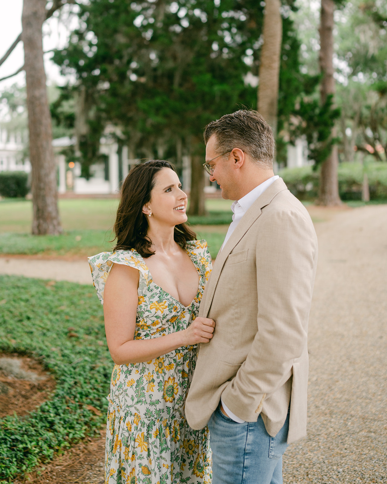 Wife and husband embrace and look towards each other during their Palmetto Bluff photoshoot.