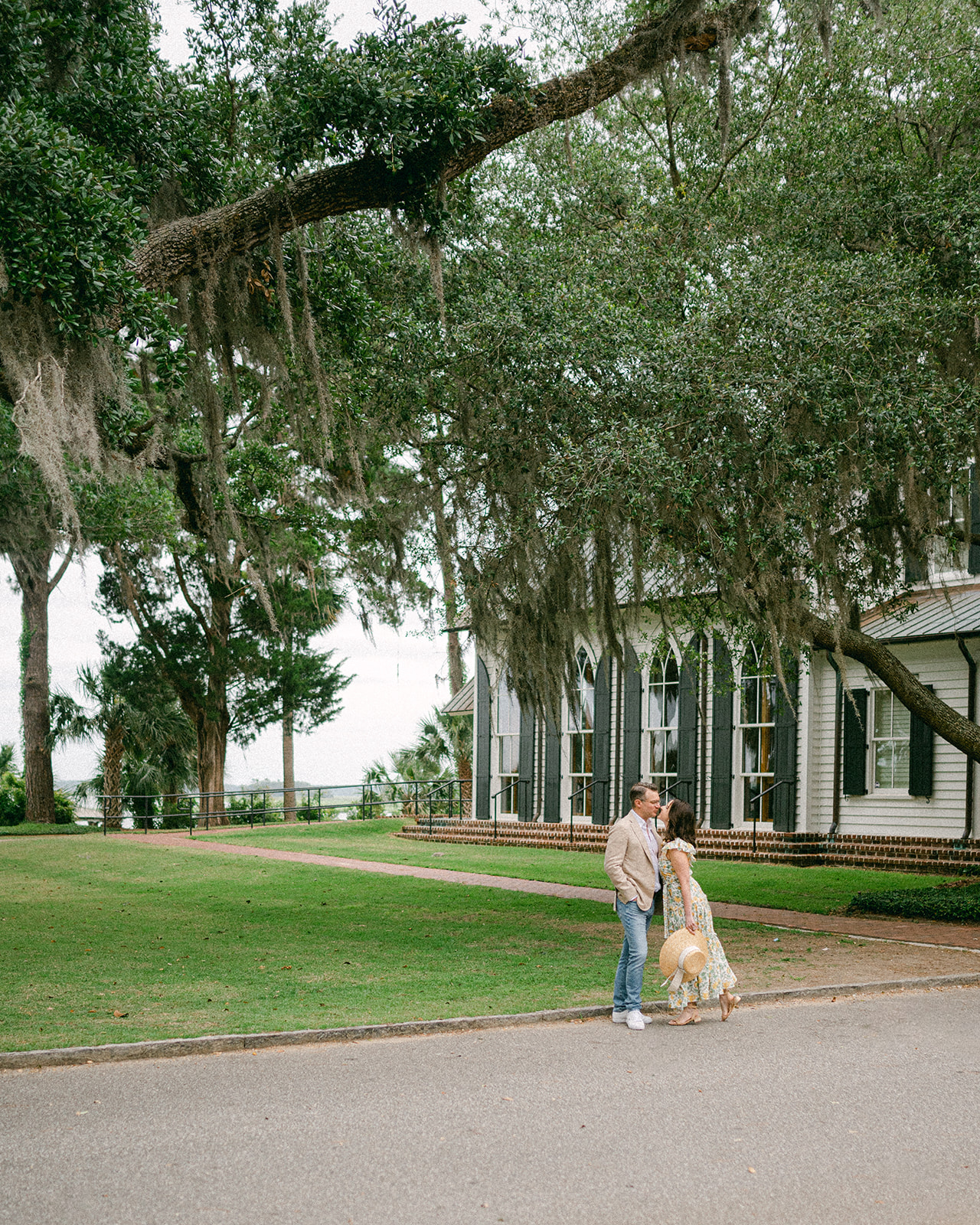 Couple kissing in front of historic building in Palmetto Bluff in South Carolina.