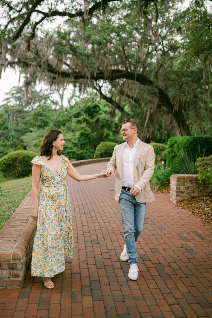 Charming couple walking on a brick path during their Palmetto Bluff anniversary photoshoot.