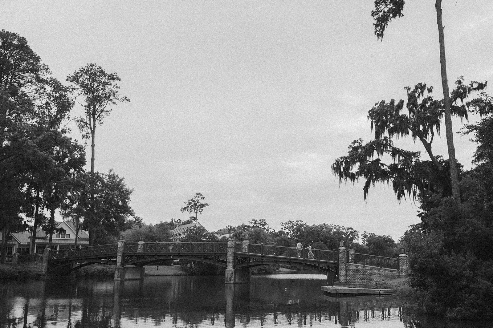 Black and white captured of Justin and Alena walking across the Palmetto Bluff Bridge toward the Village. 