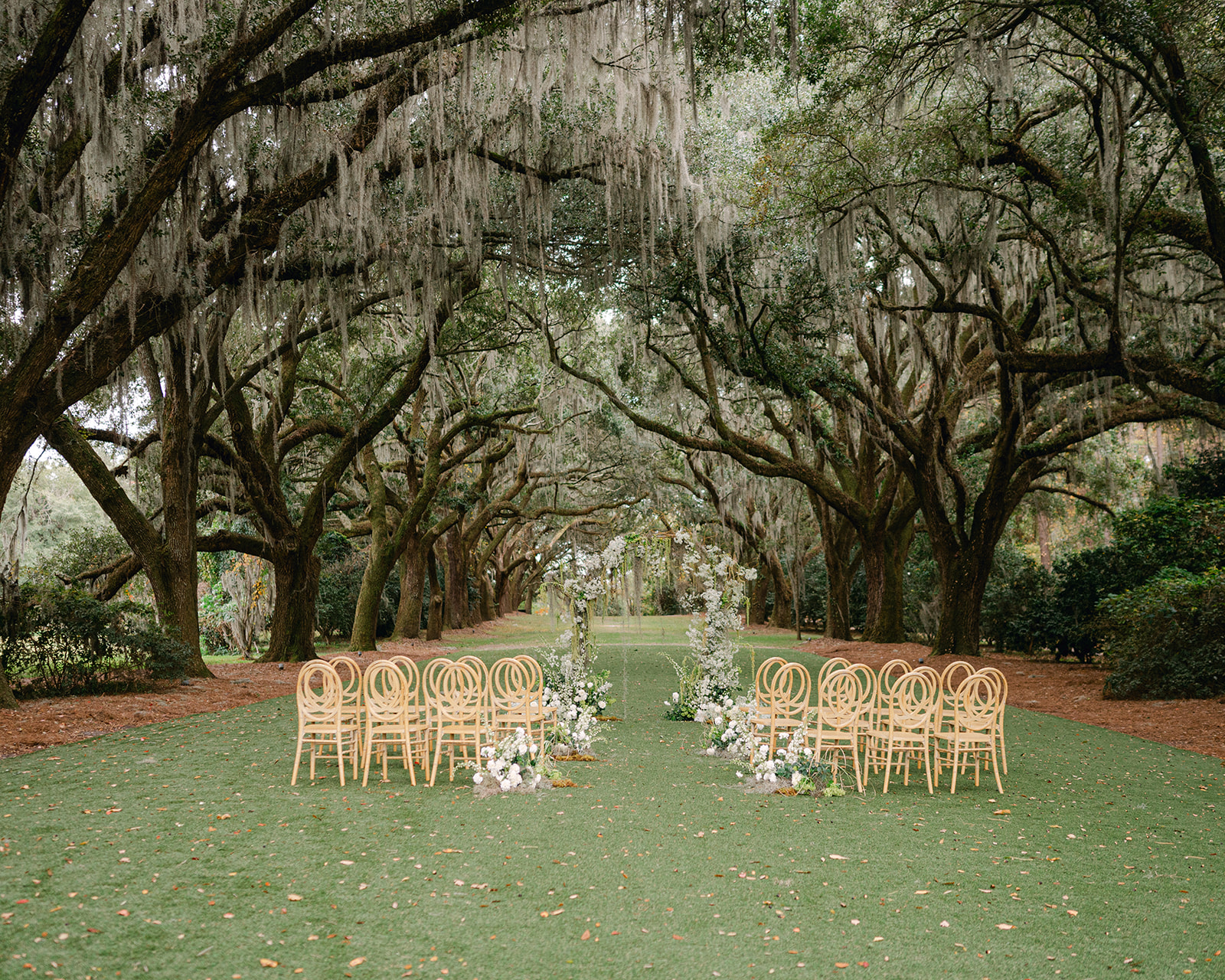 Romantic outdoor garden wedding ceremony under large oak trees at Legare Waring House in Charleston. 