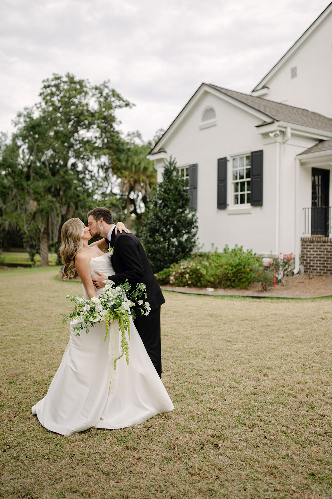 Bride and groom kissing outside their venue Legare Waring House in Charleston, SC.