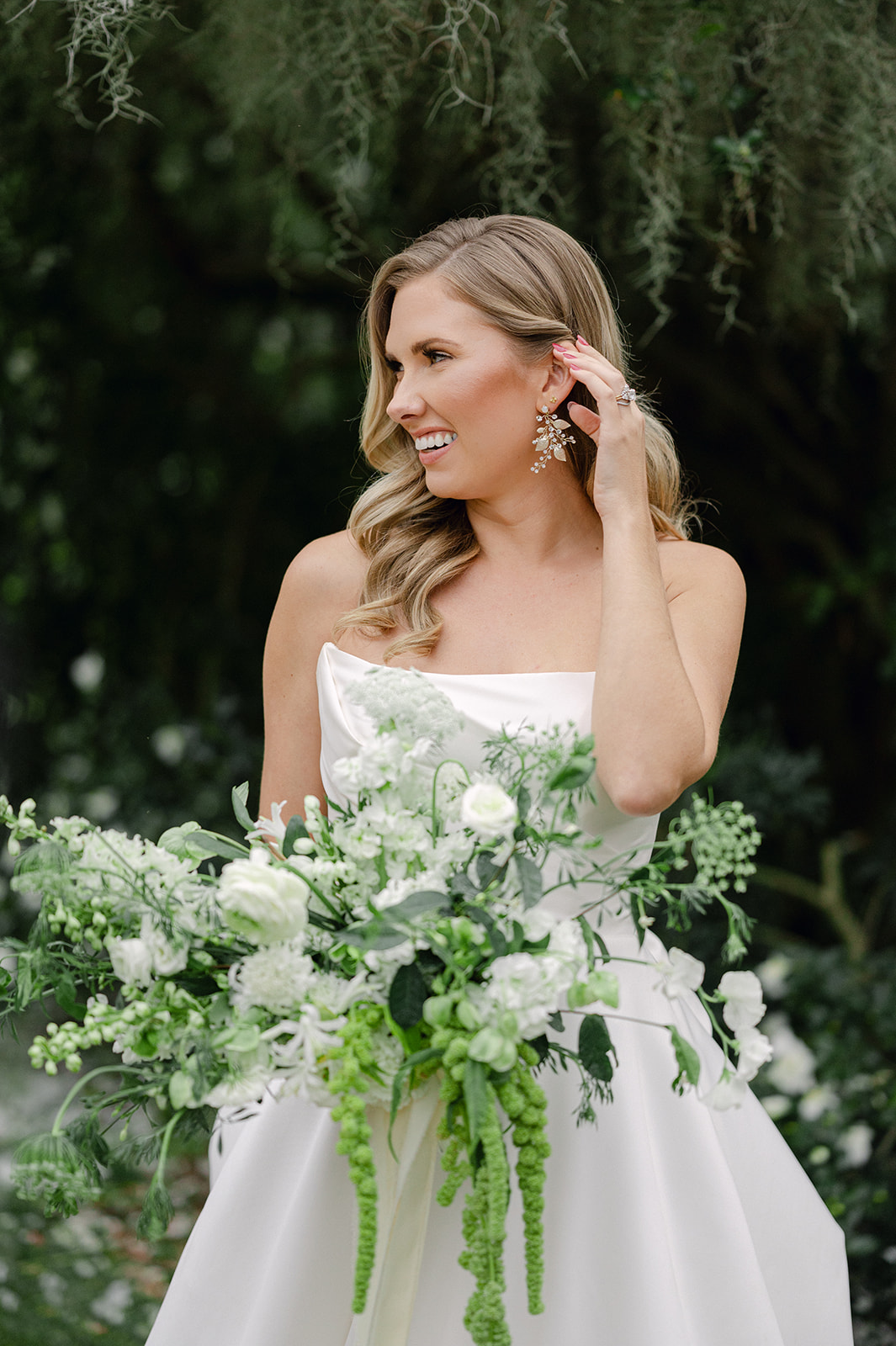 Luxury South Carolina bride holding an oversized greenery and white rose bouquet. 