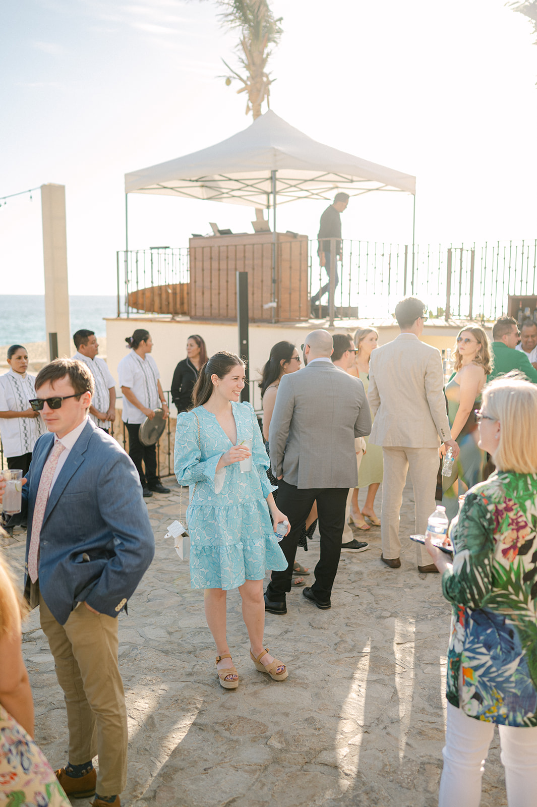 Wedding guests mingling before the beach ceremony in Cabo. 
