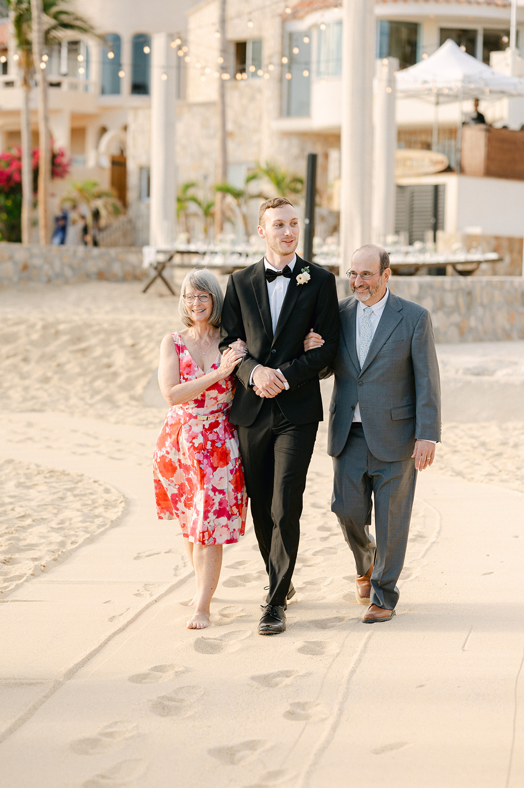 Groom walking down the sand aisle outside Villa Marcella in Cabo. 