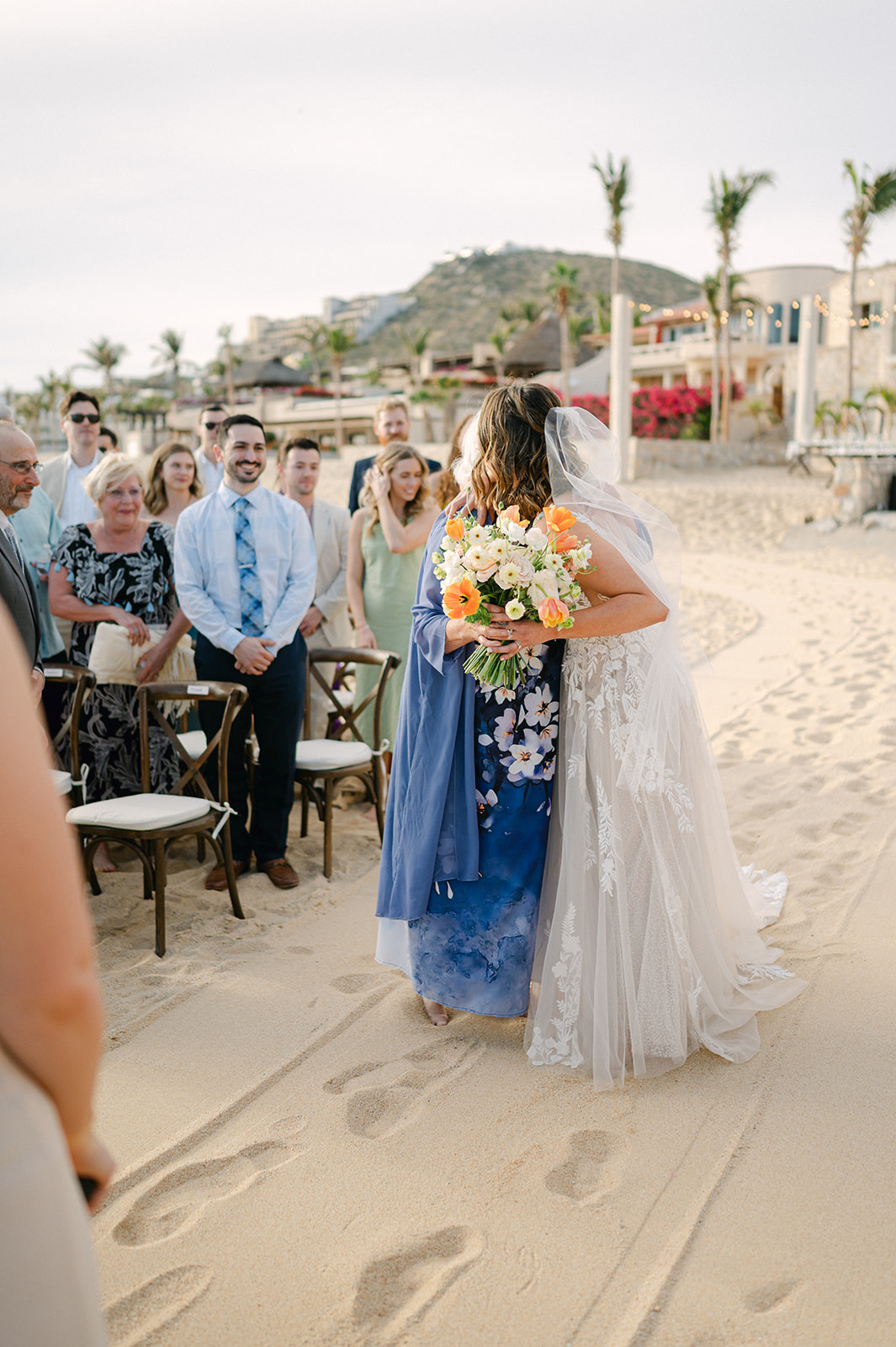 Bride hugging her grandma after walking down the aisle at her beach ceremony in Mexico. 