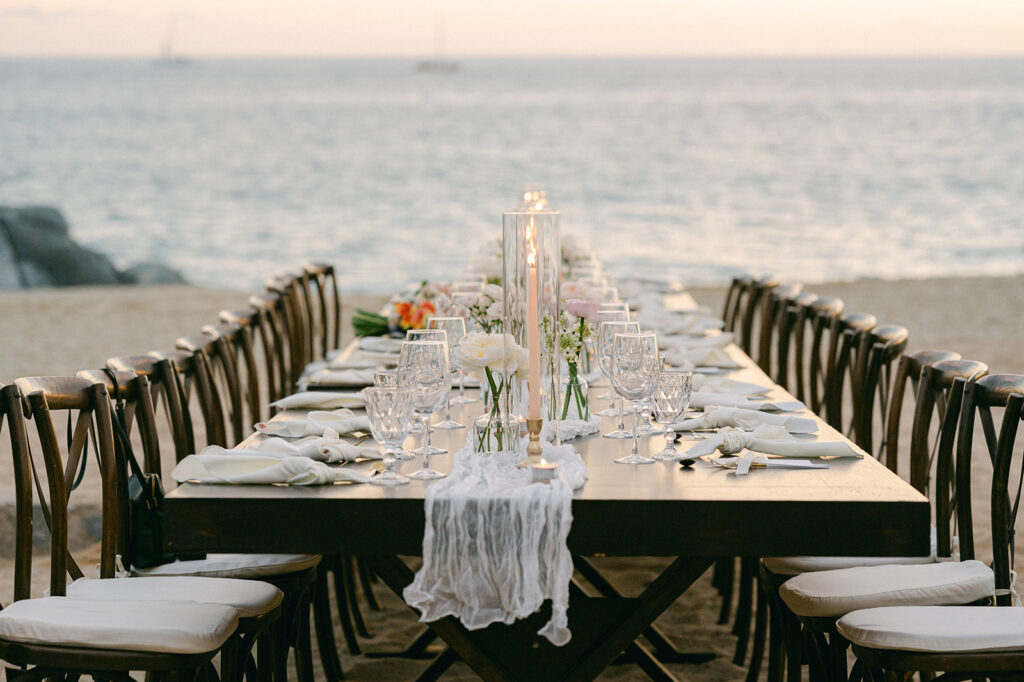 Intimate beach dinner party wedding tablescape with candles and simple decor. 