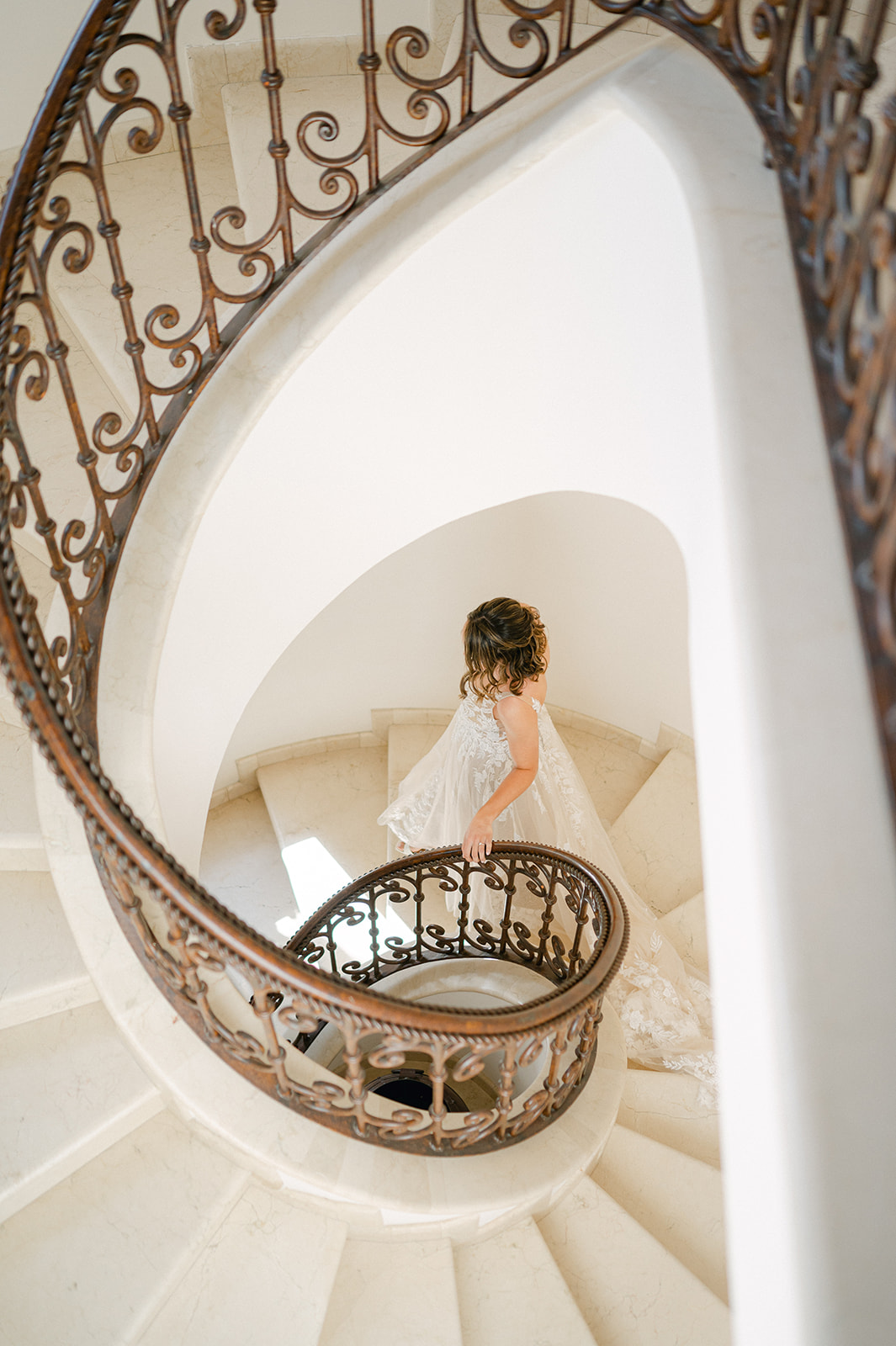 Bride walking down a spiral staircase at Villa Marcella in Cabo. 