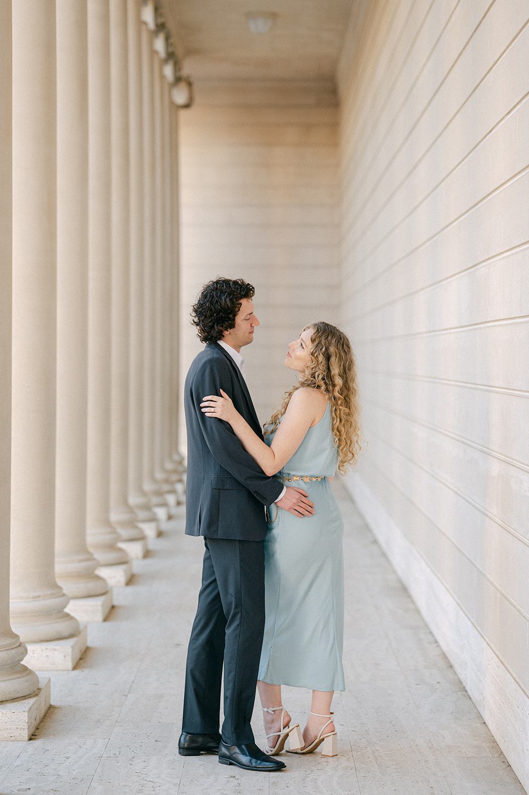 A couple stands together and embraces at Legion of Honor during their San Francisco engagement photoshoot.