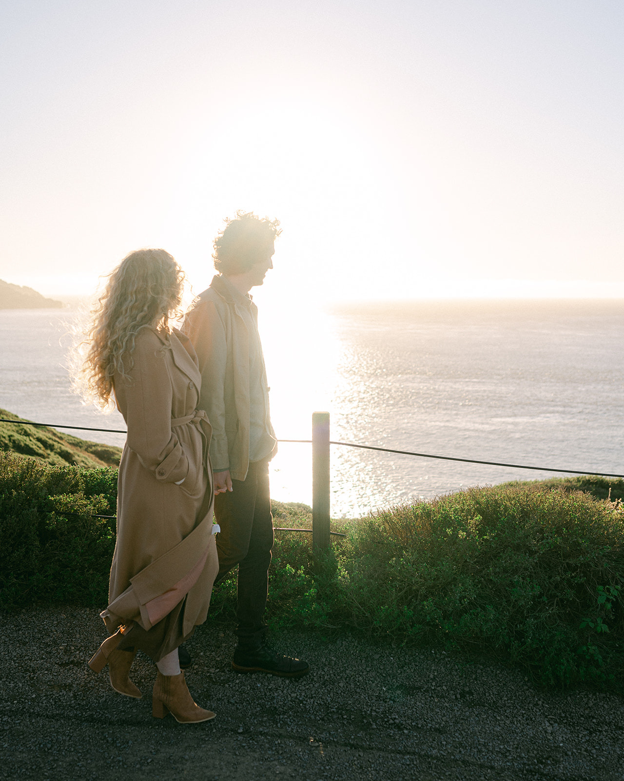Candid couple walking toward the Golden Gate Bridge overlooking the Bay. 