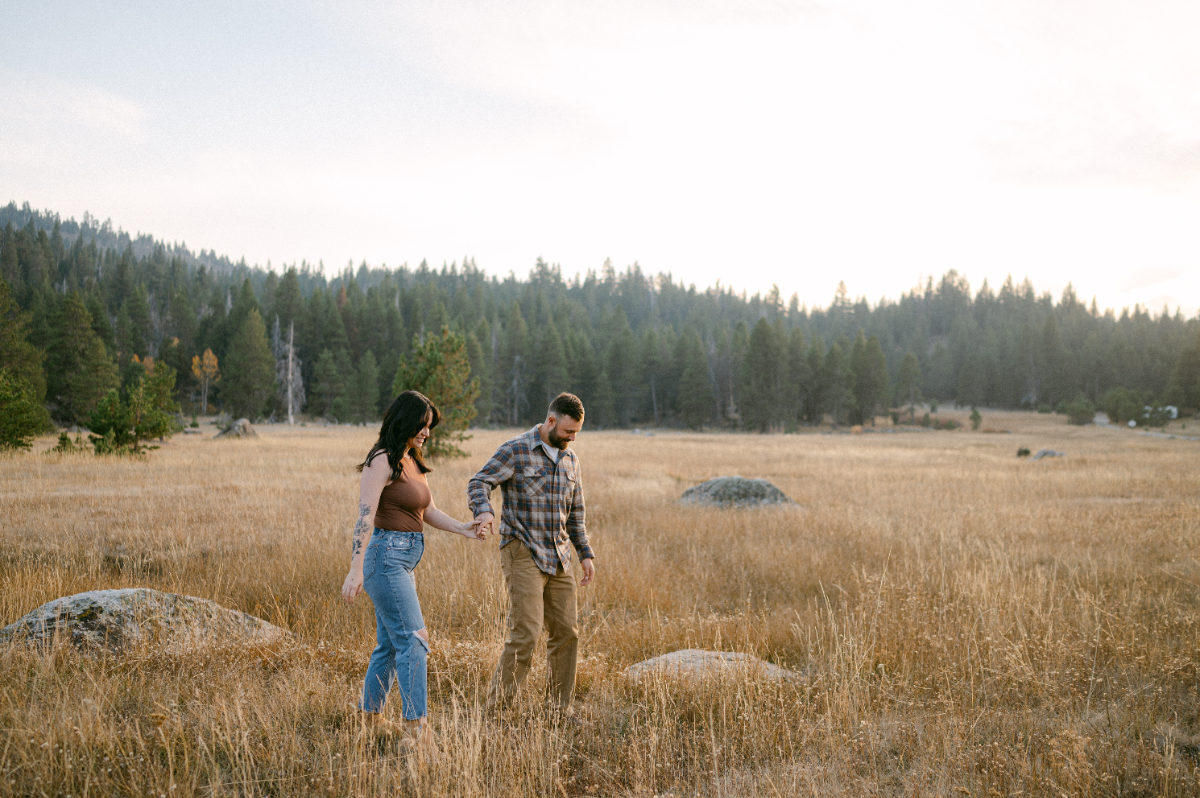 Man leads his wife through an alpine meadow in Olympic Valley near Lake Tahoe.