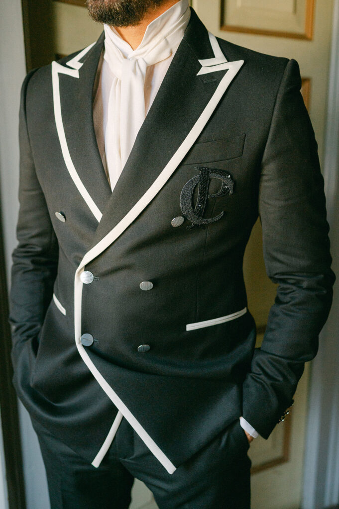 Groom custom monogrammed double-breasted suit with white accents.