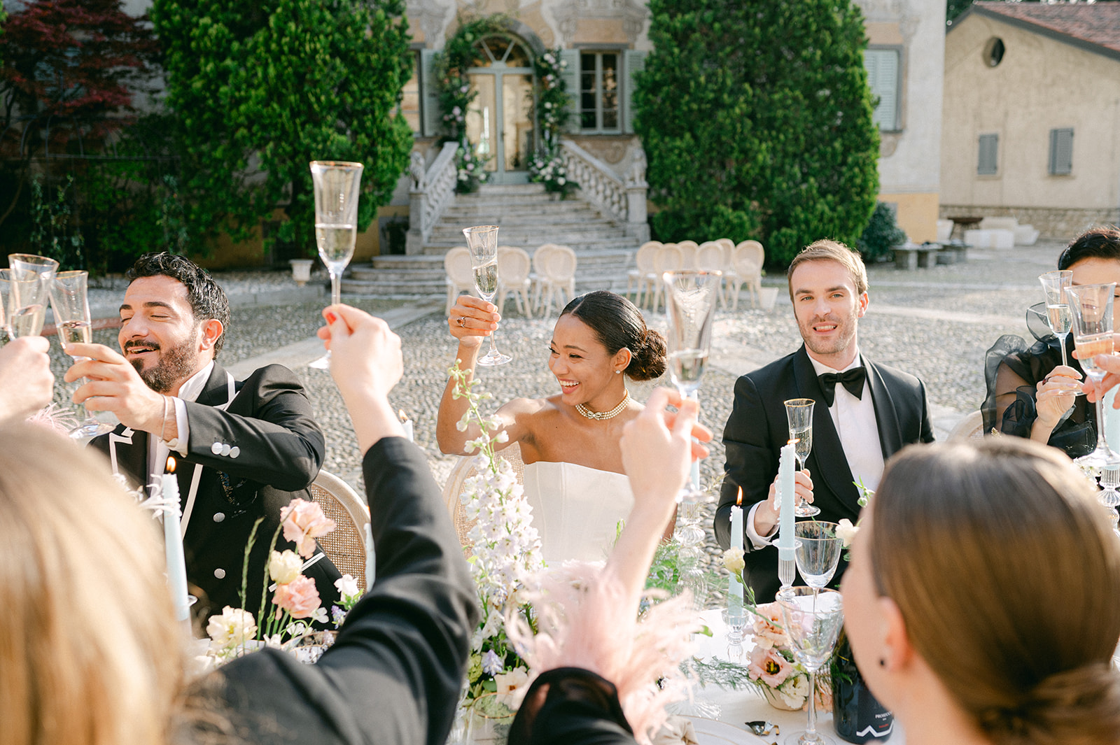 Guests sharing a toast at a garden wedding reception in Italy. 