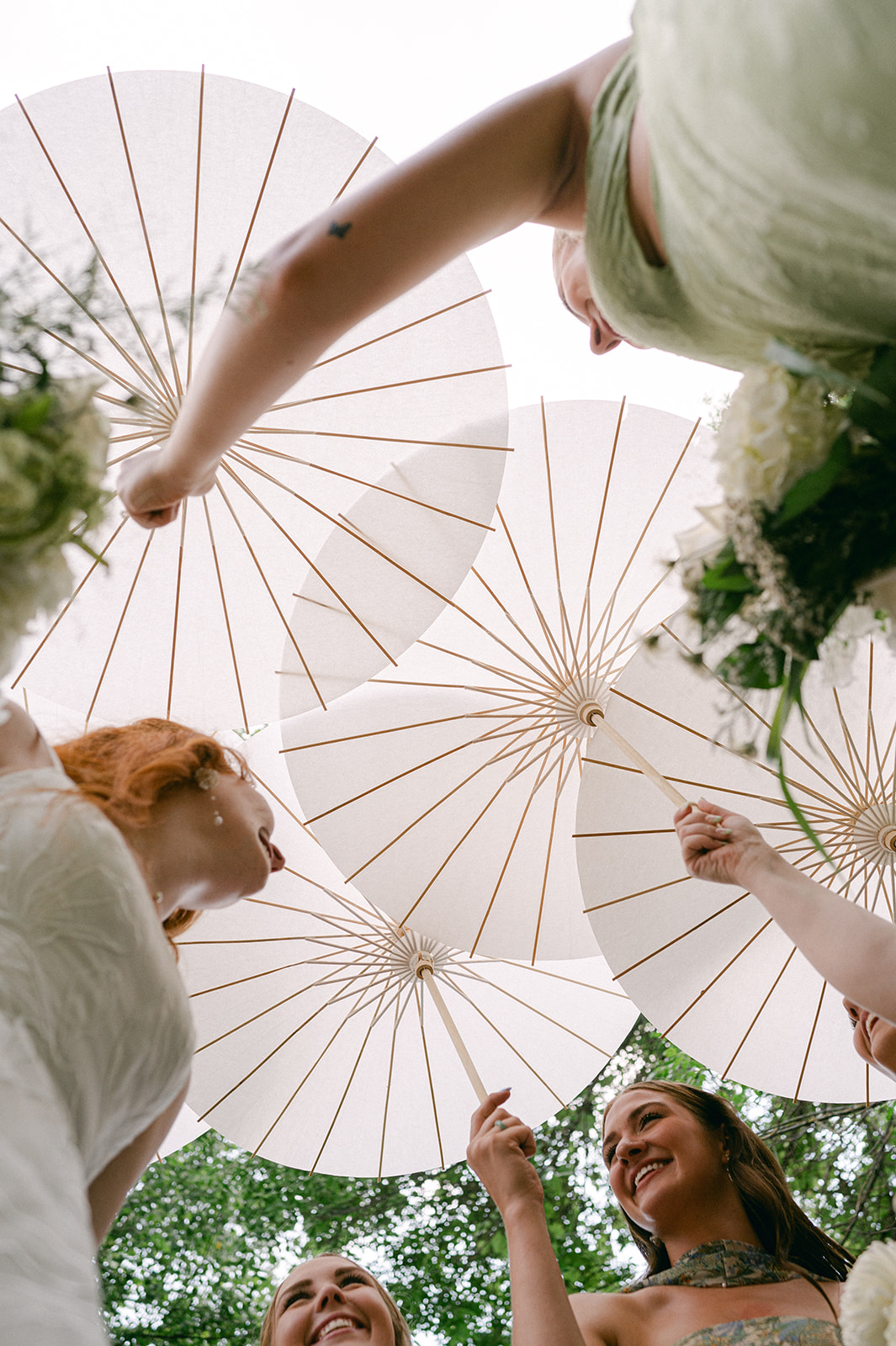 Low angle shot of a bridal party holding their vintage parasol umbrellas. 