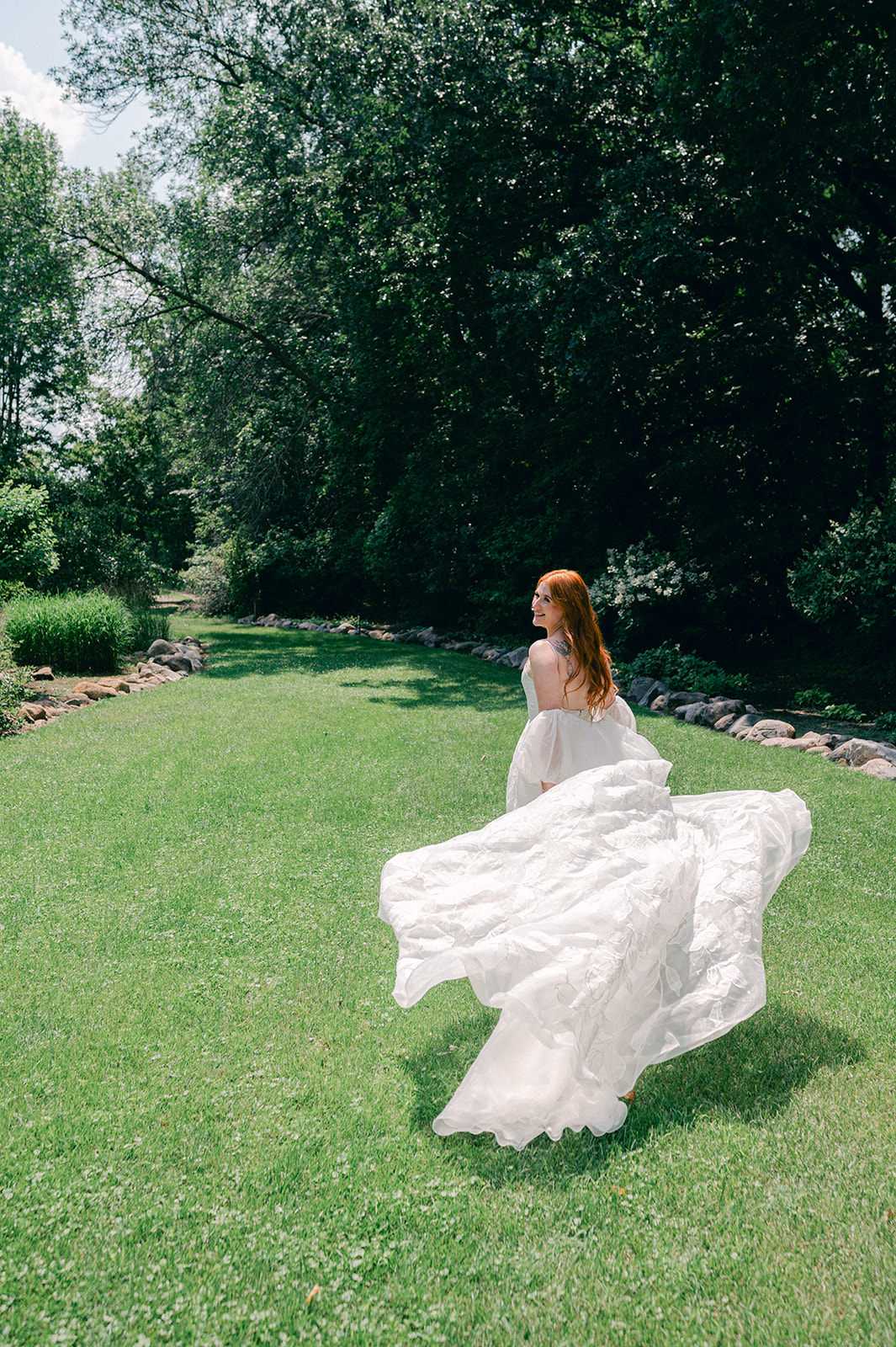 Cinematic bridal portrait with a long flowing dress train at her garden party wedding at Battle Lake, MN. 