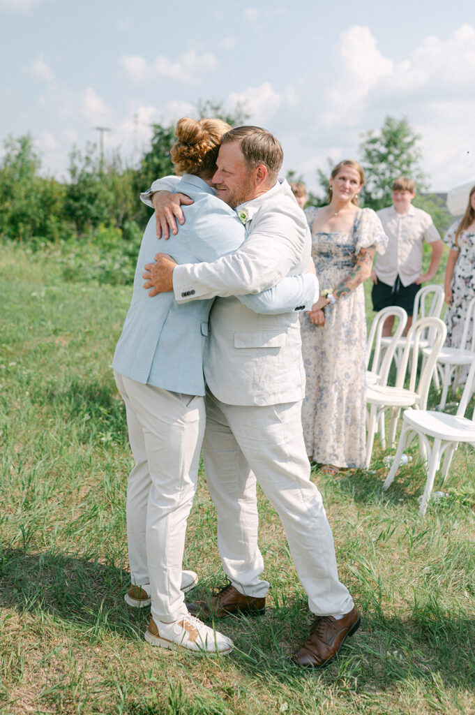 Groom hugging the bride's dad after escorting her down the aisle. 