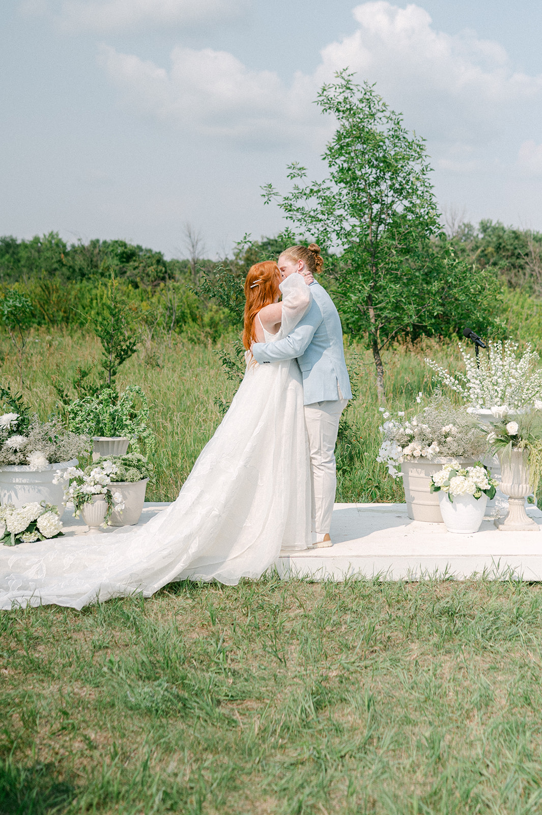 Bride and groom first kiss at their outdoor summer garden party wedding in MN. 