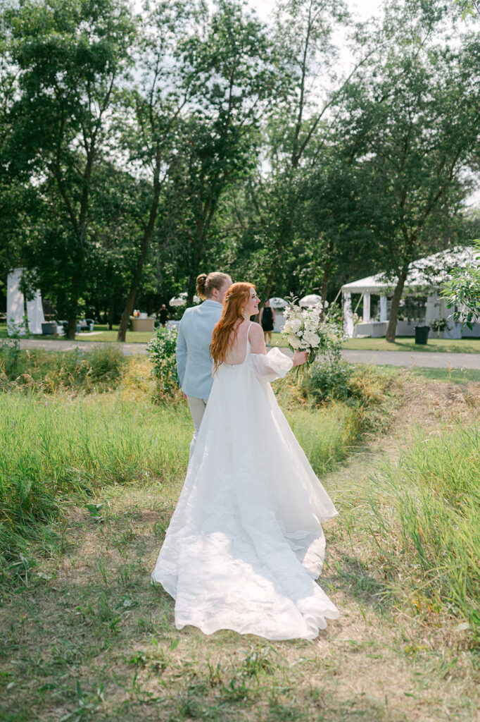 Bride and groom candid moment walking to their reception at their outdoor garden wedding. 