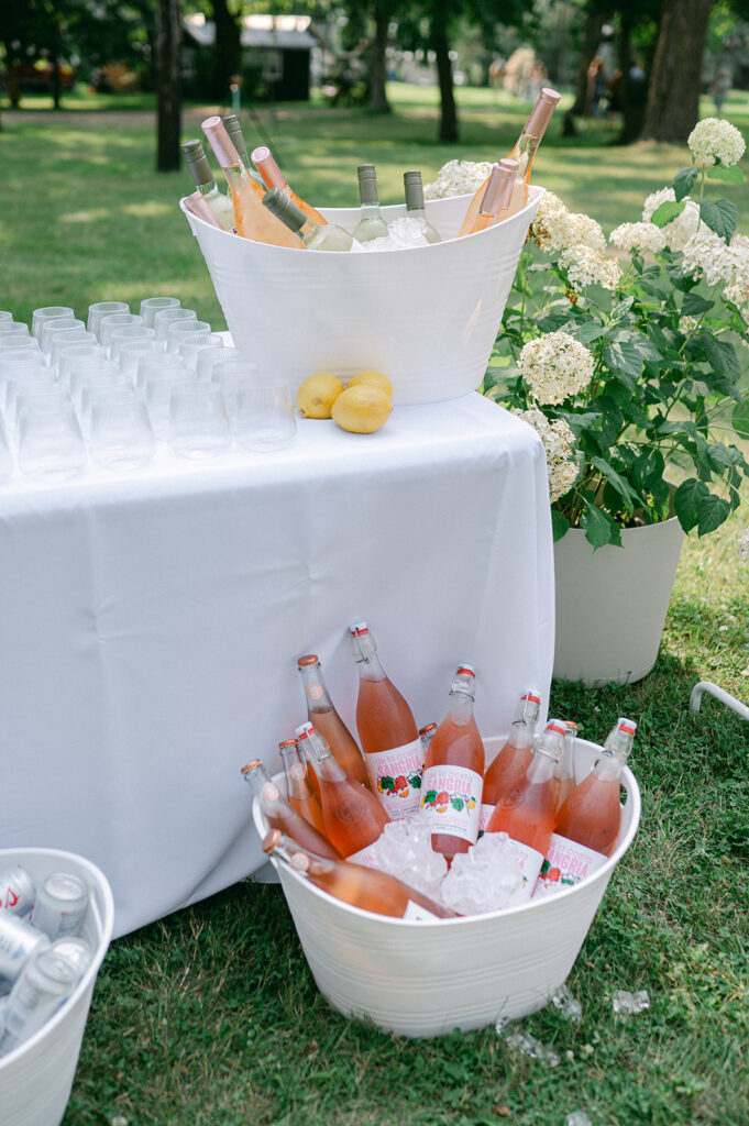 Self-serve drink table at a garden wedding.