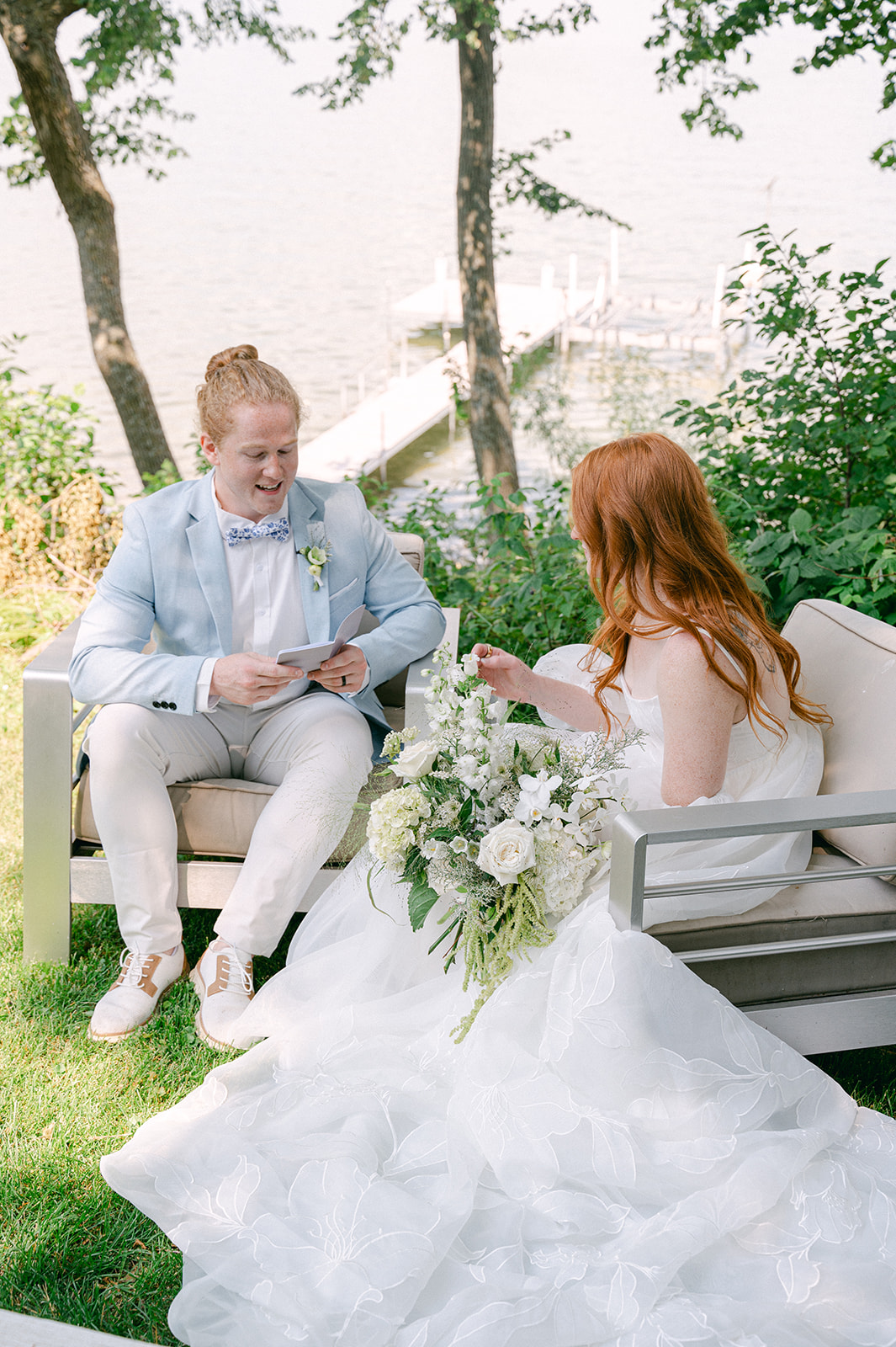 Bride and groom sharing a private vow reading by the lake before their garden wedding. 