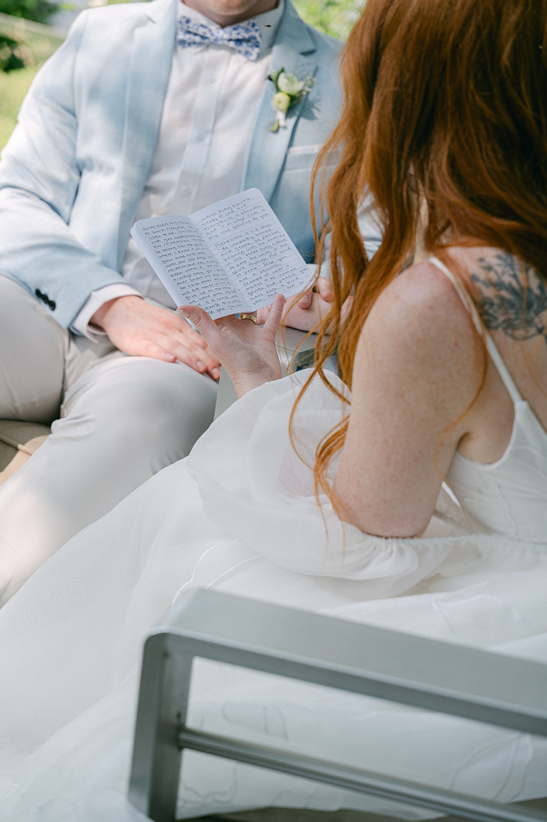 Intimate moment of the bride reading her private vows by the lake.