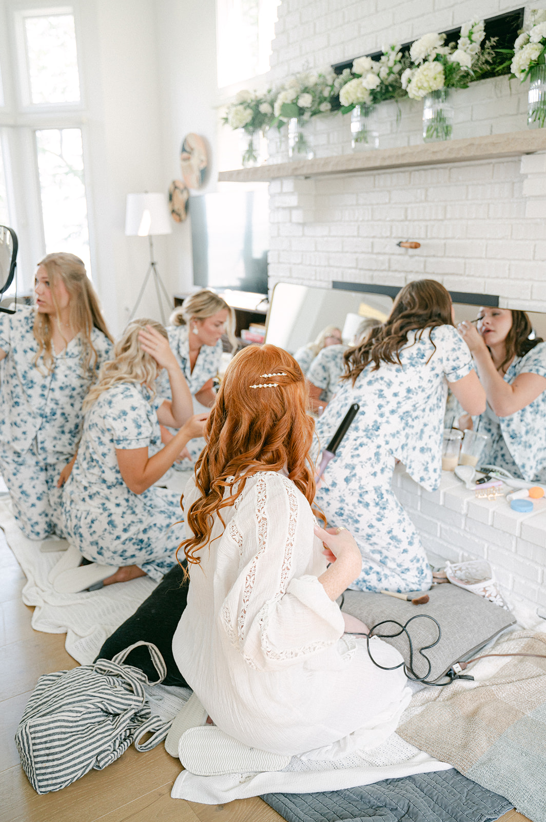 Bridal party candid in whimsical blue floral pajamas during getting ready, captured in documentary style.