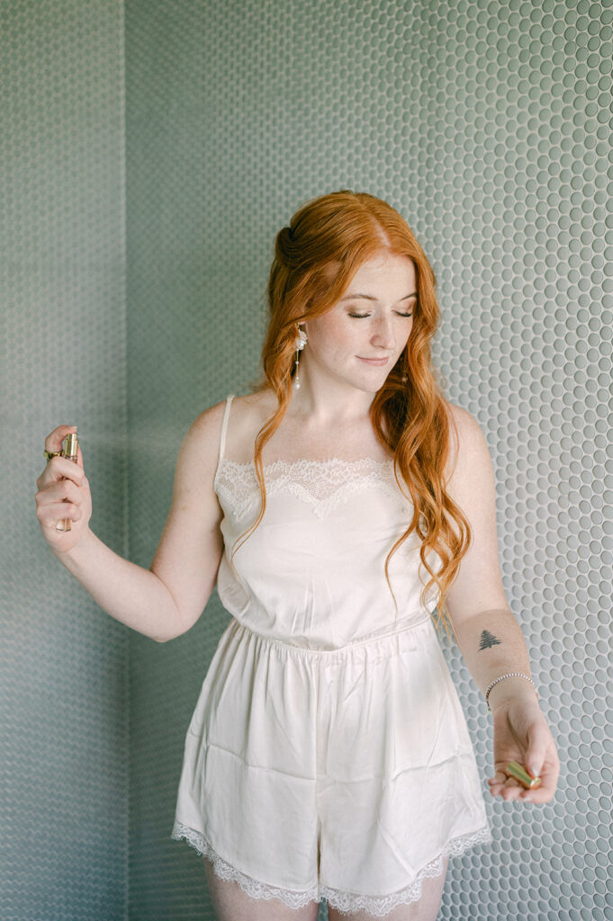 Fine art photo of the bride getting ready, captured as she sprays her perfume. 