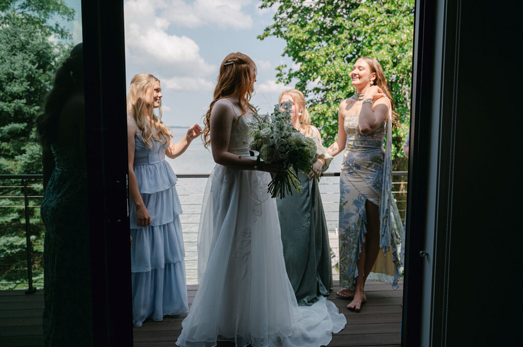 Documentary-style photo of the bride and bridesmaids gathered on the porch before the ceremony.