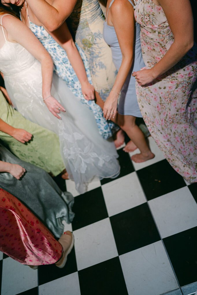 Wedding guests dancing on a checkered dance floor. 