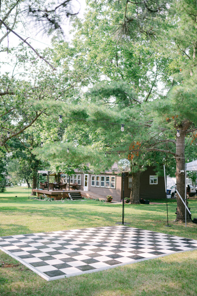 Checkered dance floor at an outdoor garden party wedding in Minnesota. 