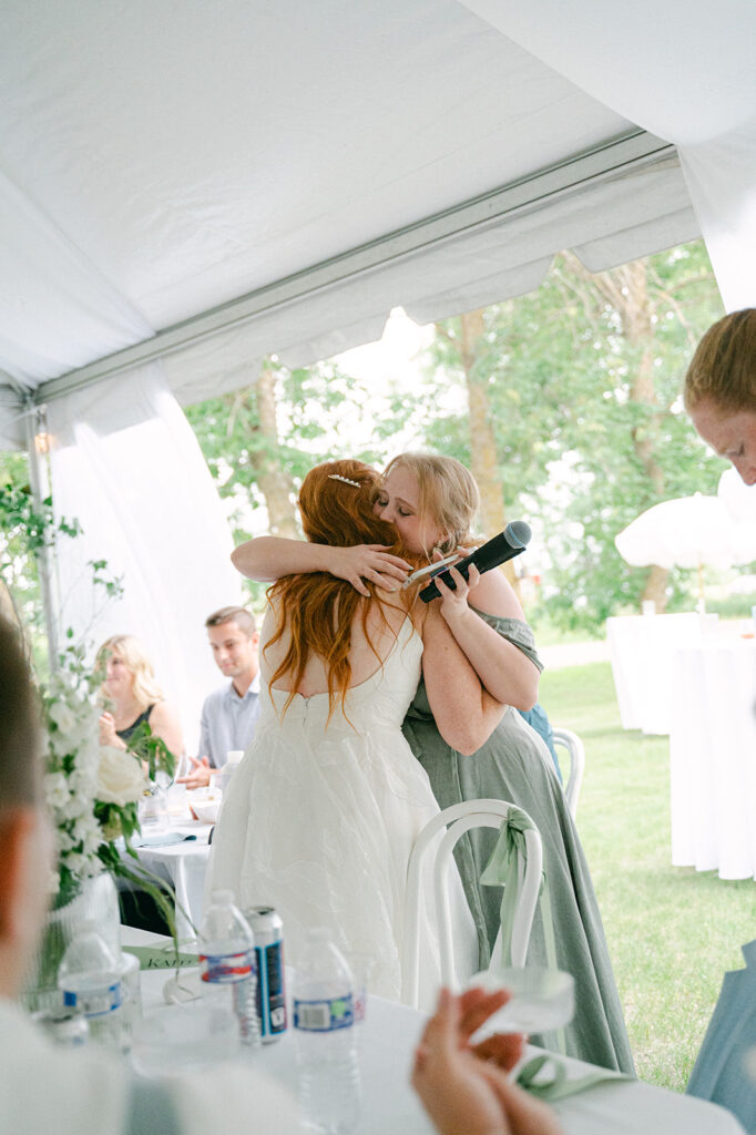 The bride hugging her bridesmaid who just gave a touching speech.